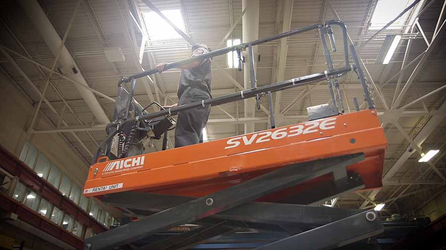 A technician being elevated in a scissor lift.