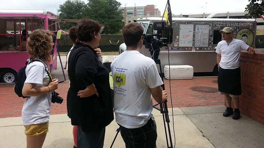 A food truck owner being interviewed in front of his truck in Raleigh, North Carolina